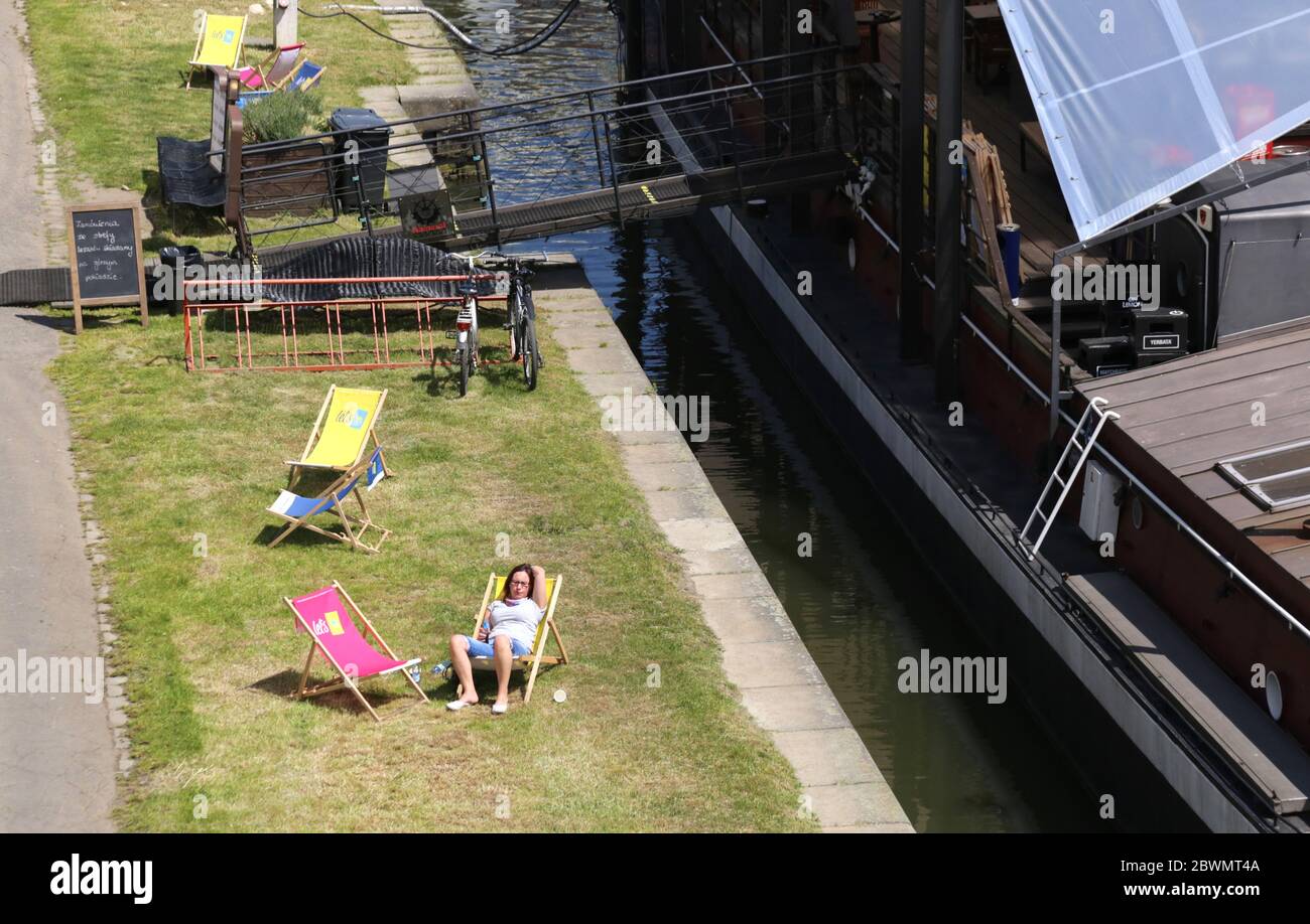 Krakau. Krakau. Polen. Eine Frau auf dem Liegestuhl am Weichselufer beim Restaurantbarge. Stockfoto