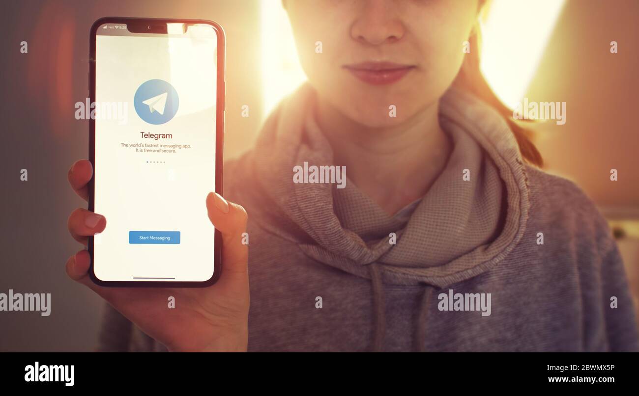 KIEW, UKRAINE-JANUAR 2020: Telegramm auf dem Bildschirm des Smartphones. Junges Mädchen zeigt Handy-Bildschirm mit Telegram auf ihm während der Blick auf die Kamera. Konzentrieren Sie sich auf Smartphone. Stockfoto