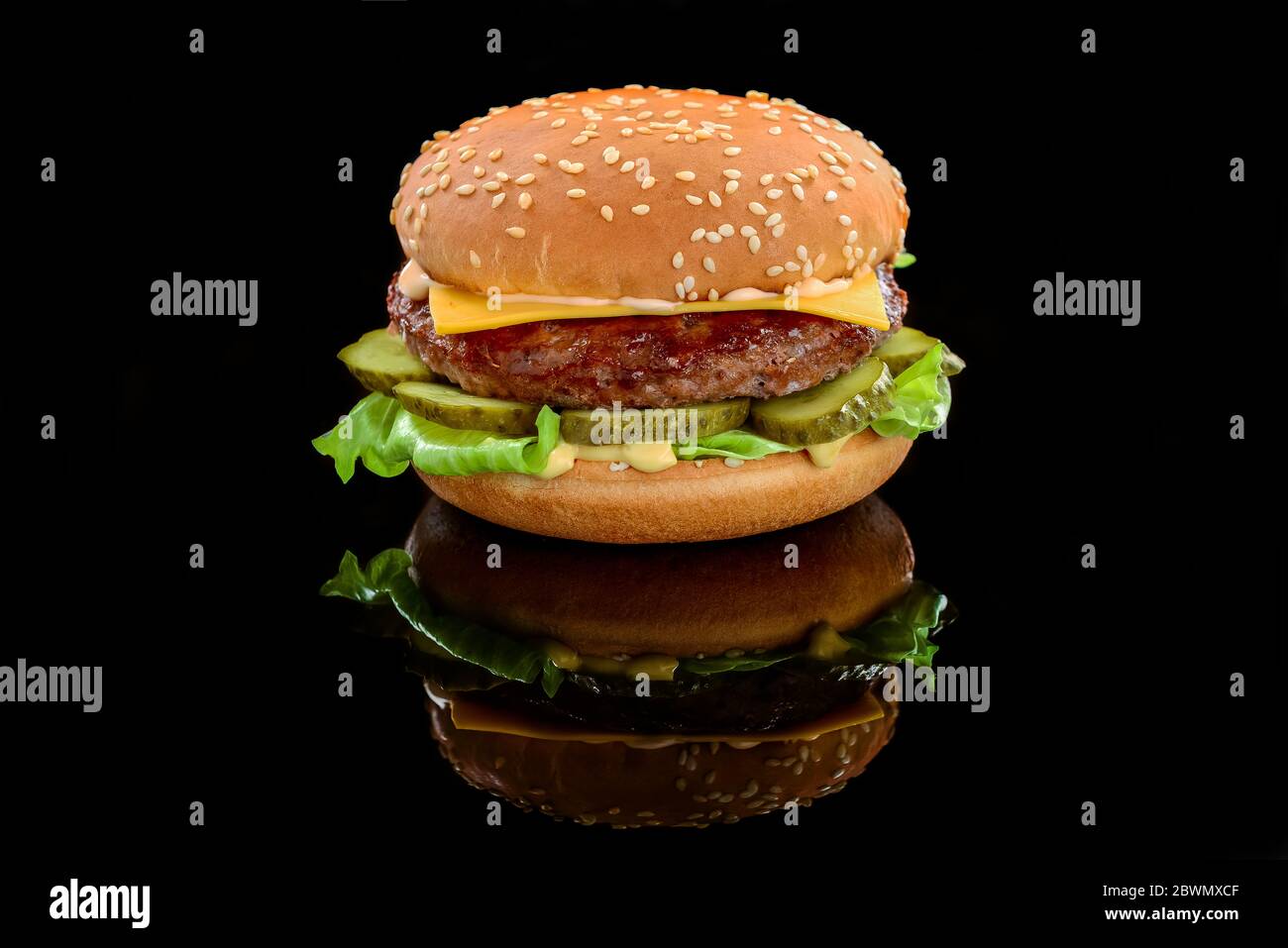 Großer leckerer Hamburger oder Cheeseburger auf schwarzem Hintergrund Stockfoto