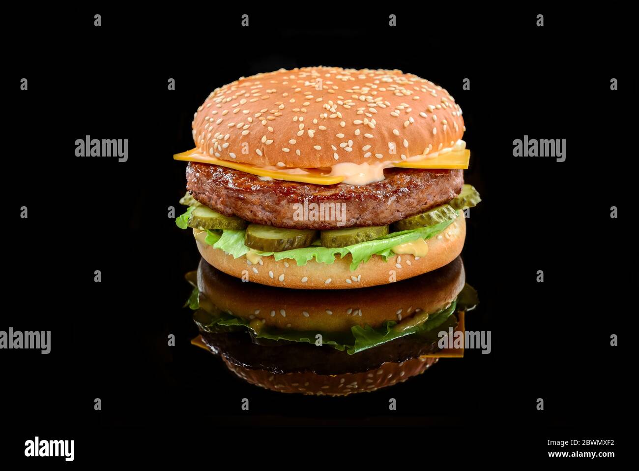 Großer leckerer Hamburger oder Cheeseburger auf schwarzem Hintergrund Stockfoto