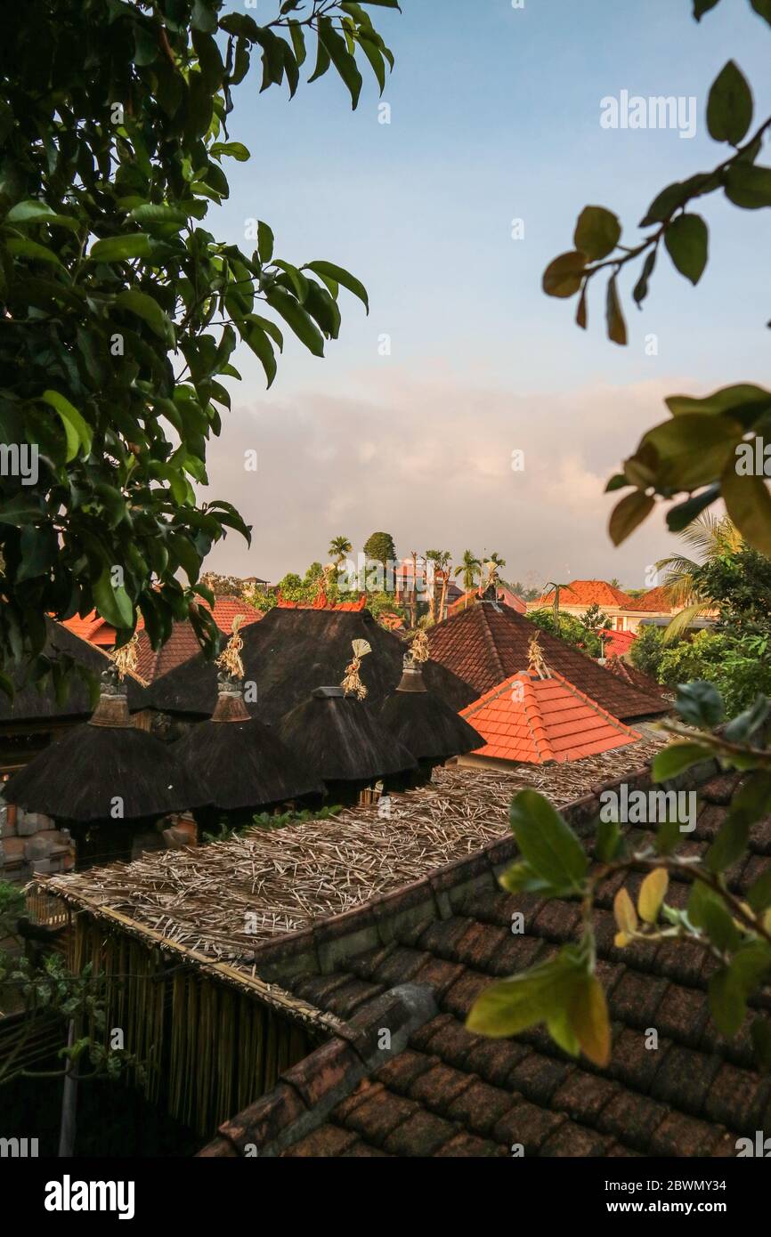Blick von oben auf die Ziegeldächer der Bali-Häuser. Sonnenaufgang im gemütlichen kleinen Ubud. Stockfoto