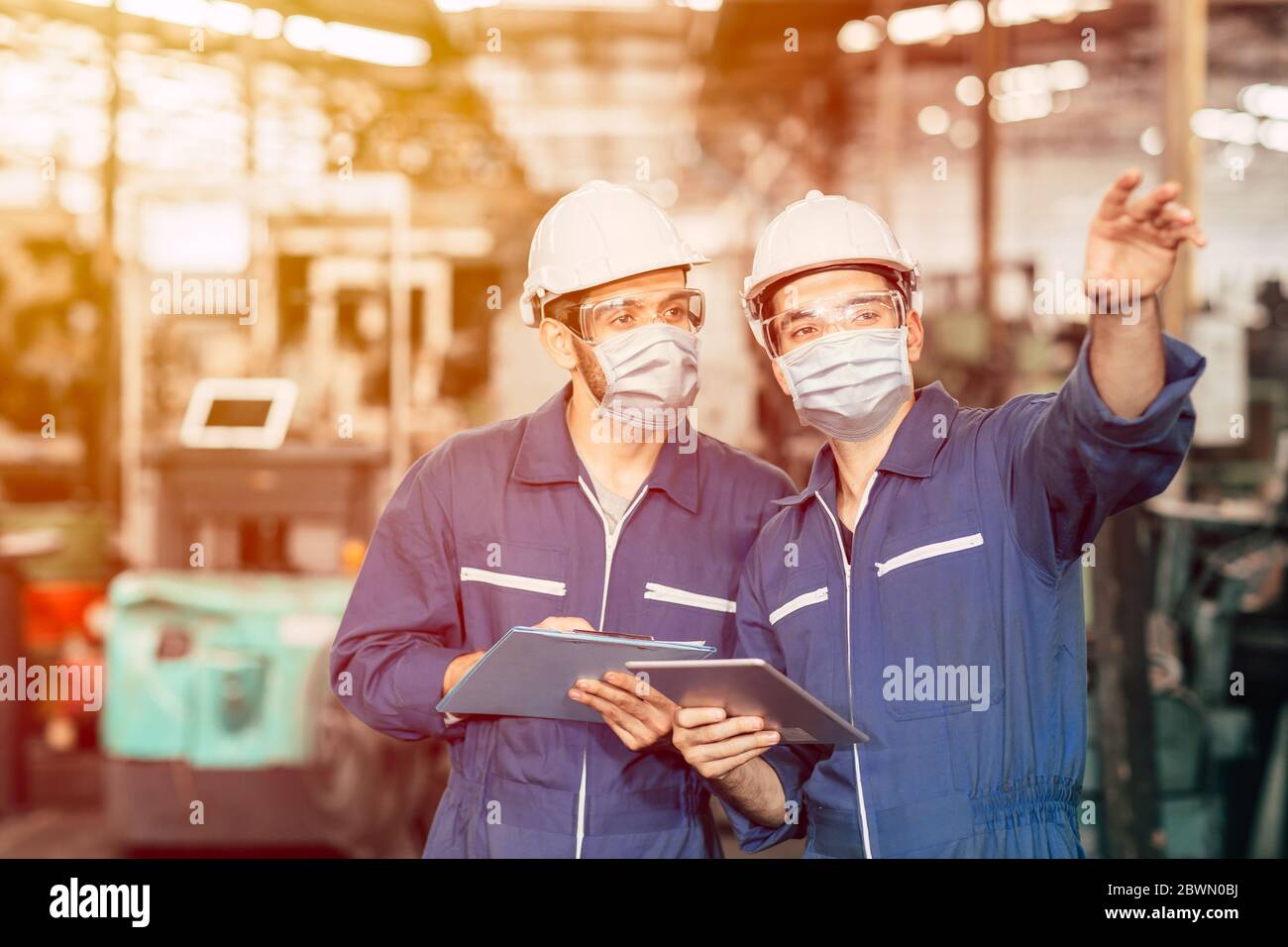 Ingenieur Teamwork Arbeiter tragen Einweg-Gesichtsmaske oder Gesichtsschutz während der Arbeit in der Fabrik zu Covid-19 Virus Luftverschmutzung und für go zu verhindern Stockfoto