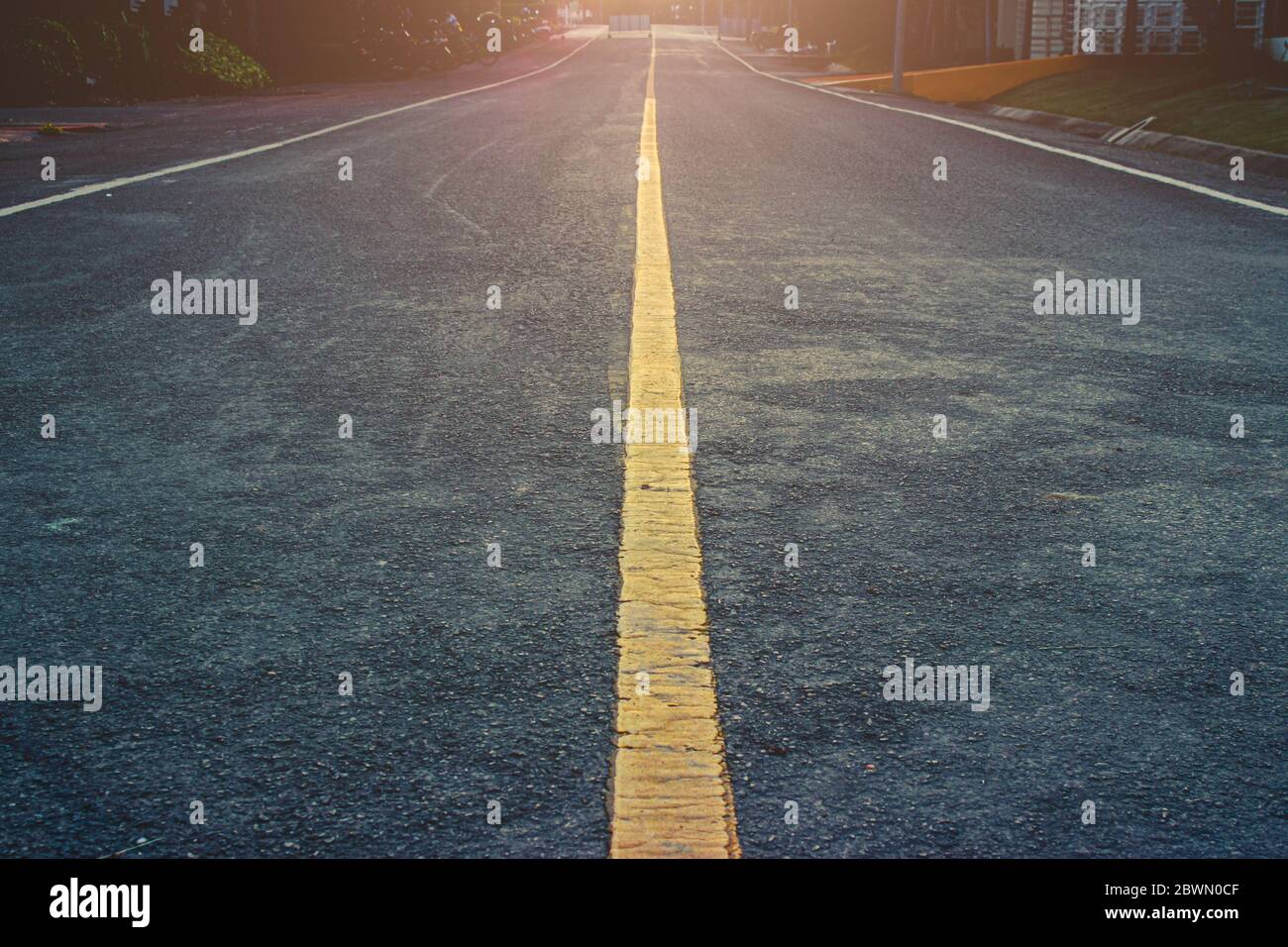 Leere gerade Straße mit gelber Mittellinie, um die Richtung des Vorwärtswegs zum zukünftigen Hintergrundkonzept zu lenken. Stockfoto