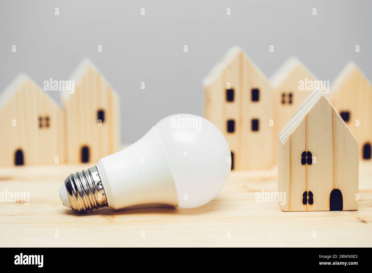 LED-Glühbirne mit Holz-Dekoration für Eco-Haus-Beleuchtung niedrigen Stromverbrauch und Energieeinsparung Community-Konzept. Stockfoto