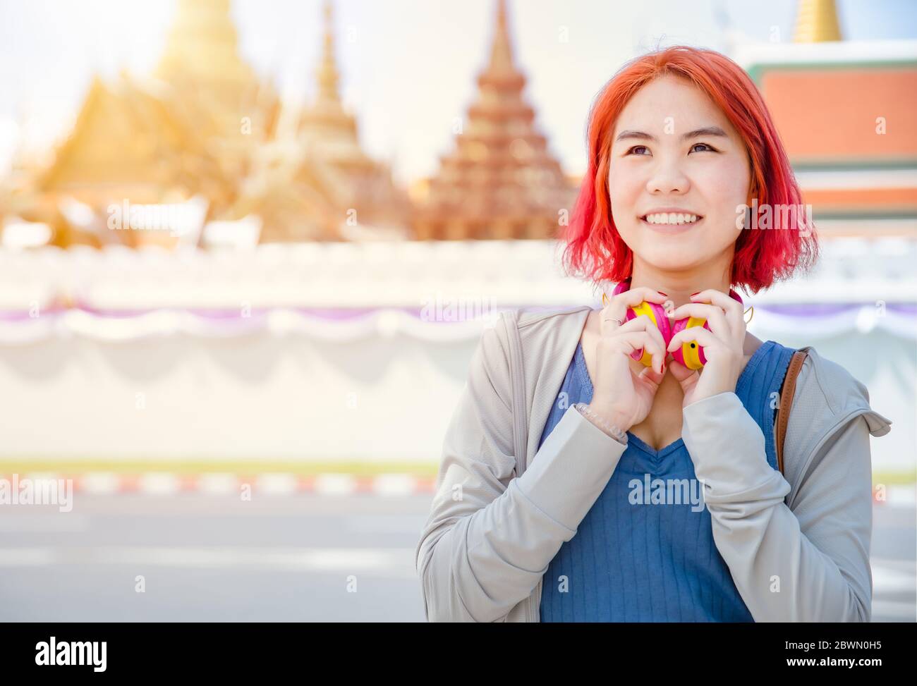 Porträt Thai Asian Mädchen neue Generation junge Pop teen gefärbt roten Haar Farbe Schatten lächelnd mit Thailand Tempel Hintergrund. Stockfoto