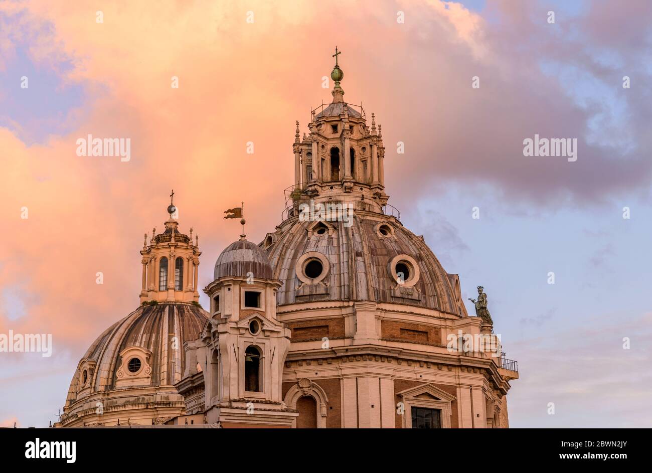 Sunset Dome - Nahaufnahme von Sonnenuntergang über den Kuppeln der Kirche Santa Maria di Loreto und dem Heiligen Namen Mariens im Trajan Forum. Rom, Italien. Stockfoto