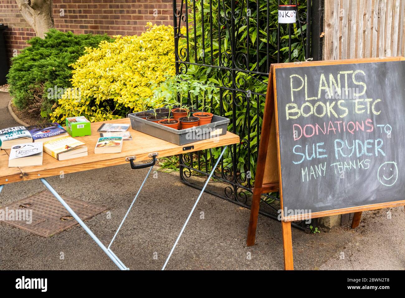 Eine Tischpflanze und Buchverkauf zur Unterstützung eines lokalen Hospiz außerhalb eines privaten Hauses in Gloucester UK während der Covid 19 Pandemie Stockfoto