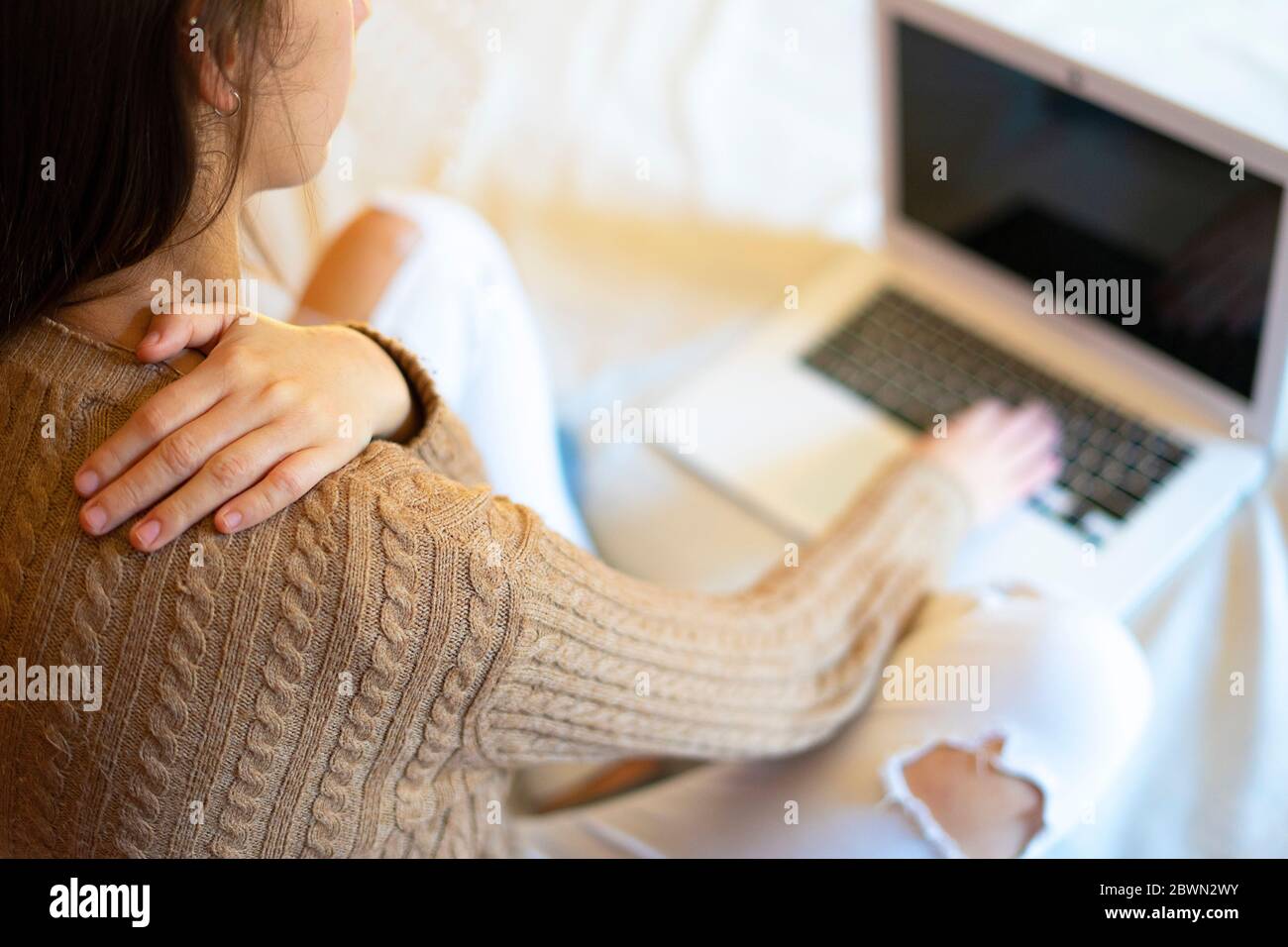 Büroangestellte mit Rückenschmerzen durch die Arbeit mit dem Computer. Ergonomie bei der Arbeit. Stockfoto