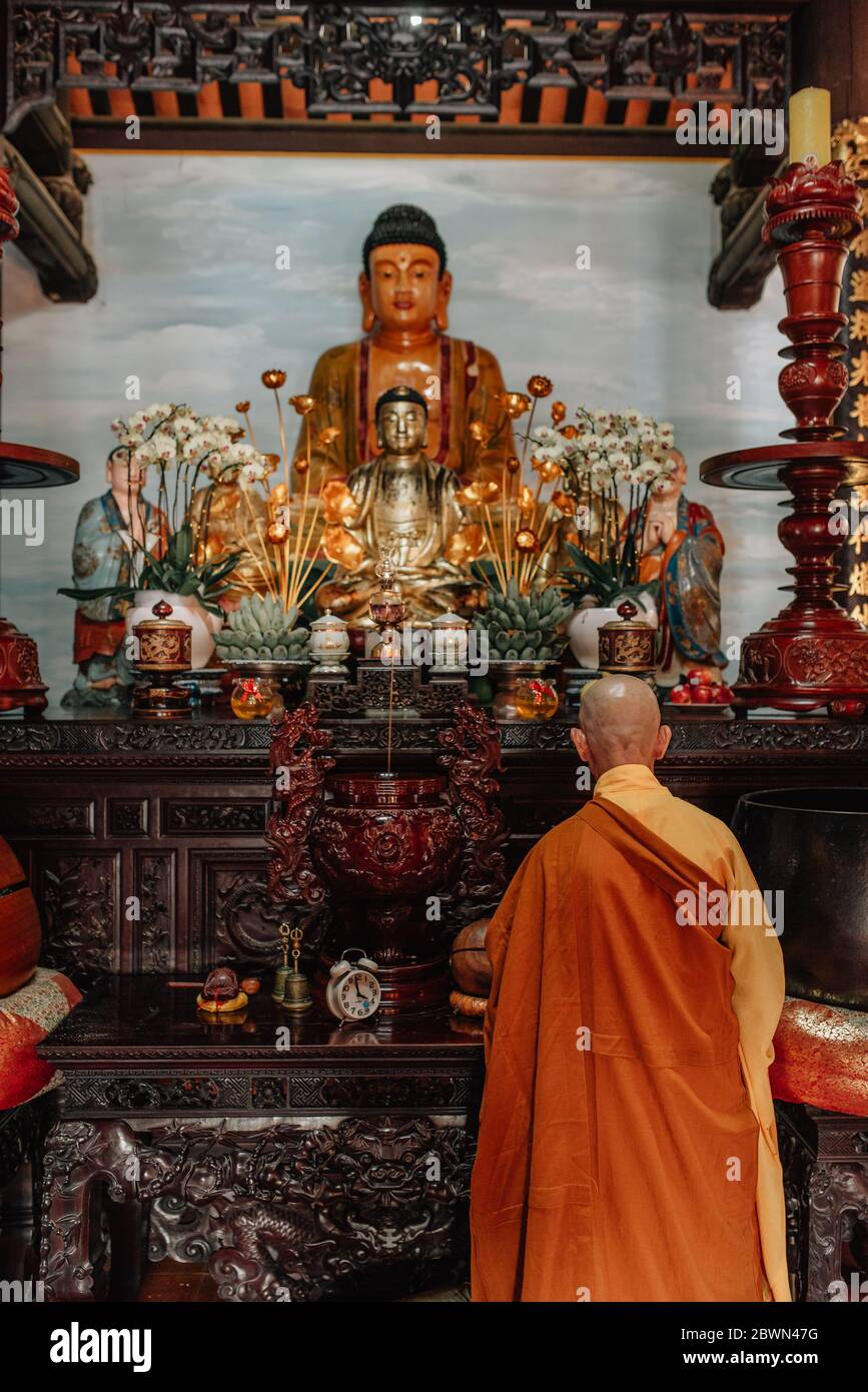 Buddhistischer Mönch, der vor einem goldenen buddha betet BÃ¡i ÄÃ­nh Tempel i Stockfoto