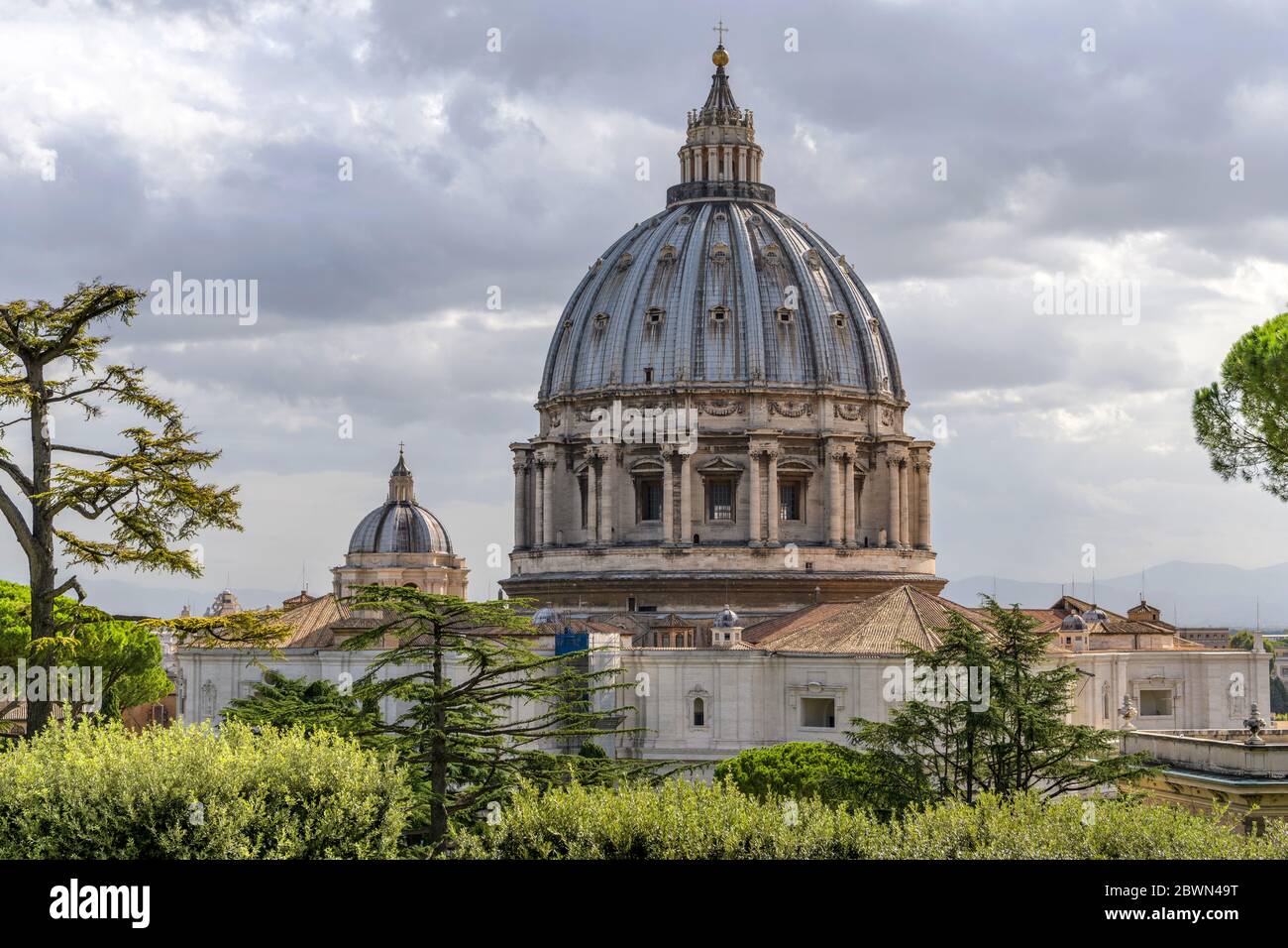 Petersdom - Nahaufnahme der Kuppel des Petersdoms, von den Vatikanischen Gärten aus gesehen, an einem bewölkten Oktobermorgen. Vatikanstadt, Rom. Stockfoto