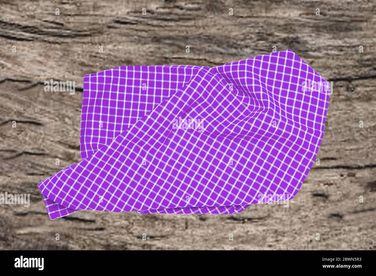 Topview aus leerem violett kariertem Küchentuch, Textil, Tischdecke oder Serviette auf einem verschwommenen rustikalen Holzhintergrund. Vorlage für Lebensmittel und Produkt di Stockfoto