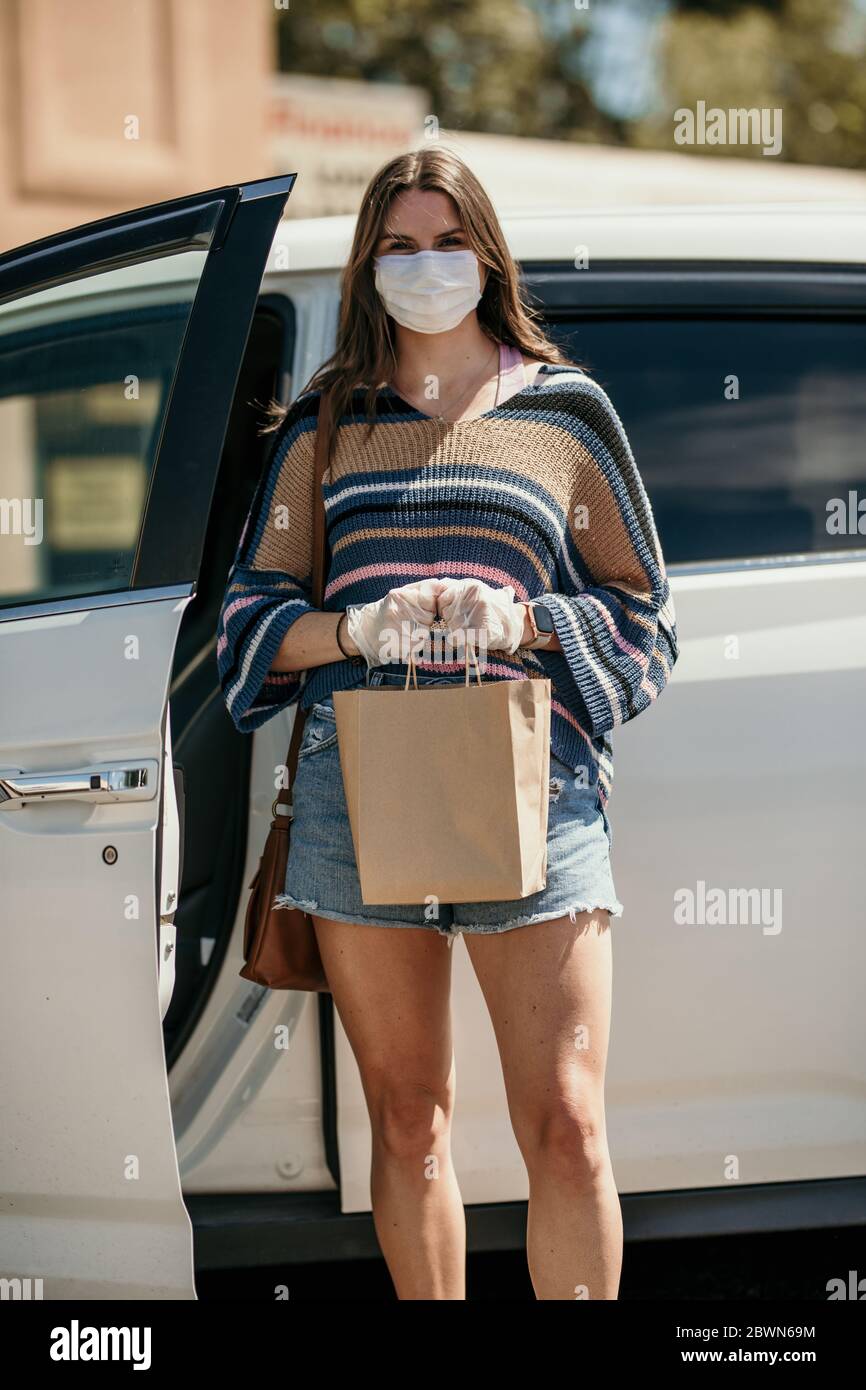 Mädchen einkaufen mit Maske und Handschuhe während covid 19 Corona Virenkrise Stockfoto
