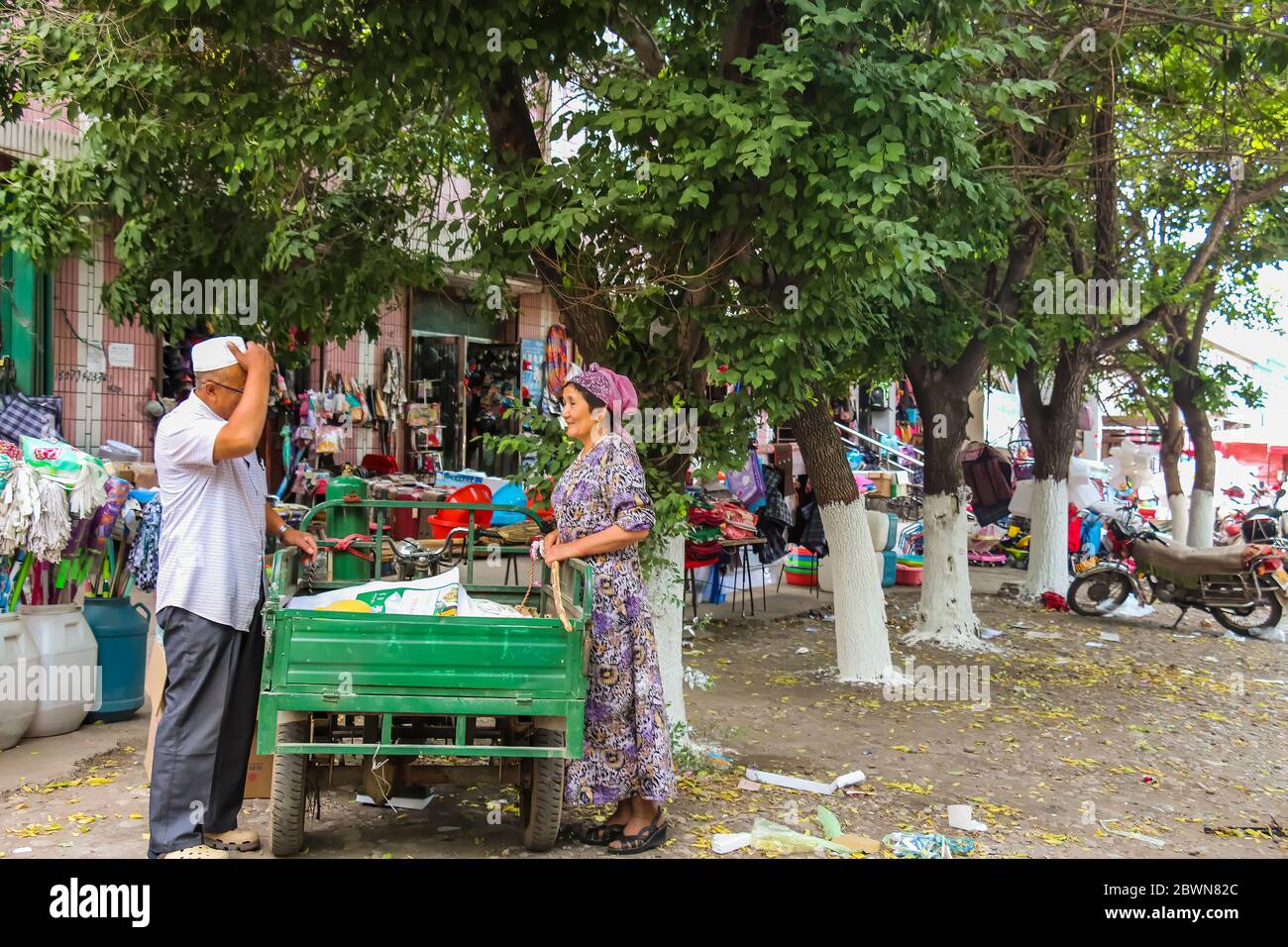 Yining, Xinjiang, China - 13. Juli 2014: Uiguren Frau und Mann kommunizieren in einem Unterbezirk in Yining auf den Straßen Stockfoto
