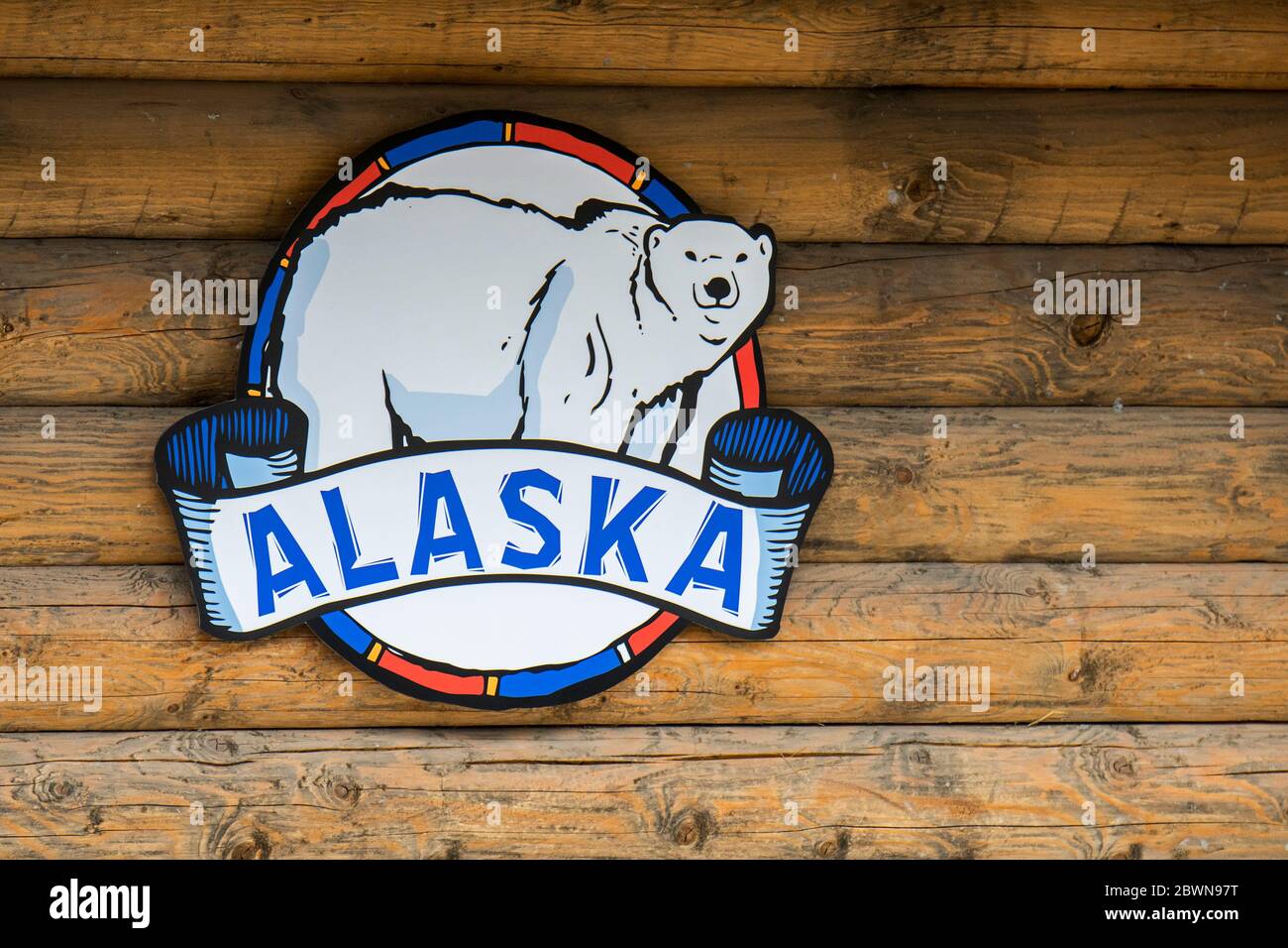 Alaska / Alaska Emblem / Insignien mit Eisbär Symbol hängen an der Holzwand der Blockhütte Stockfoto