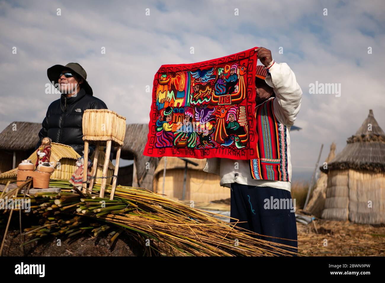 Die Uros-Gemeinschaft zeigt ihr Handwerk, während Touristen ihre schwimmende Insel aus Totorareed am Titicaca-See in Peru besuchen. Stockfoto