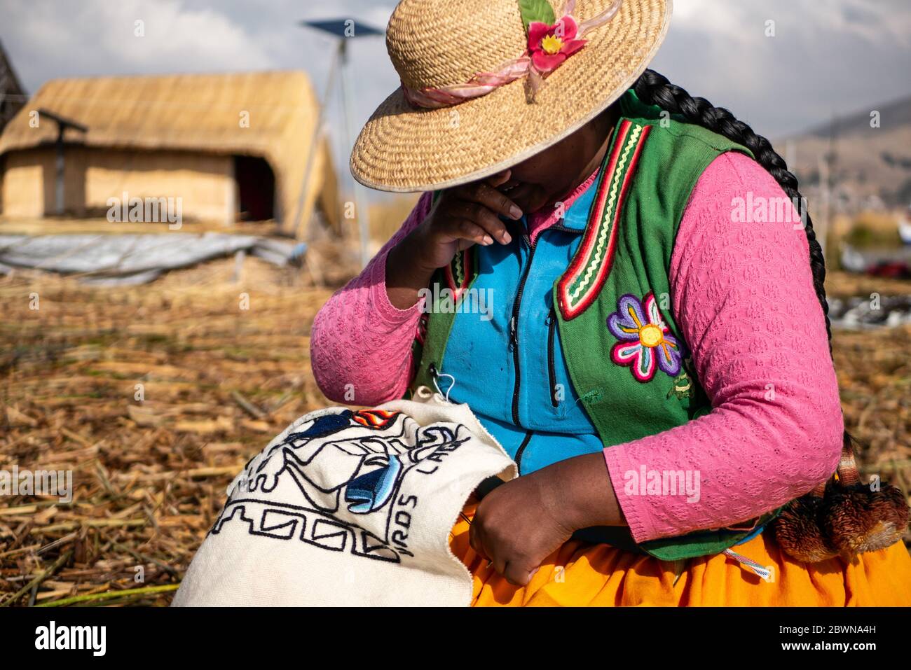 Die Uros-Gemeinschaft zeigt ihr Handwerk, während Touristen ihre schwimmende Insel aus Totorareed am Titicaca-See in Peru besuchen. Stockfoto