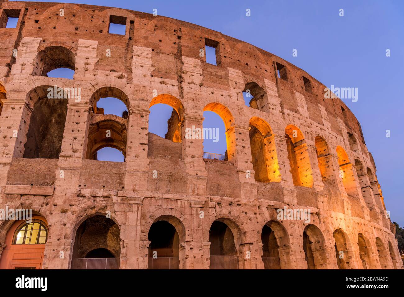 Äußere Wand des Kolosseums - Nahaufnahme von tiefen Winkel Dämmerung Blick auf den oberen Abschnitt der südwestlichen Wand des Kolosseums, gegen klaren blauen Himmel. Rom, Italien. Stockfoto
