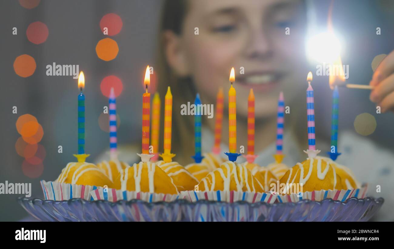 Teen Mädchen Lichter Kerzen auf Kuchen an ihrem Geburtstag Stockfoto