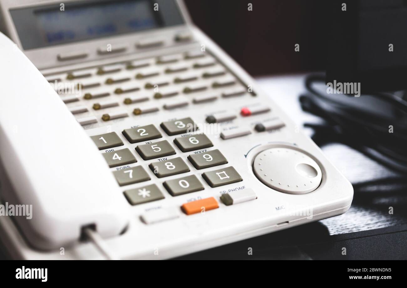 Bürokommunikation, Business-Telefonsystem, Festnetztelefon auf dem Schreibtisch, Nummernblock in der Nähe. Telemarketing und Telekommunikation Stockfoto