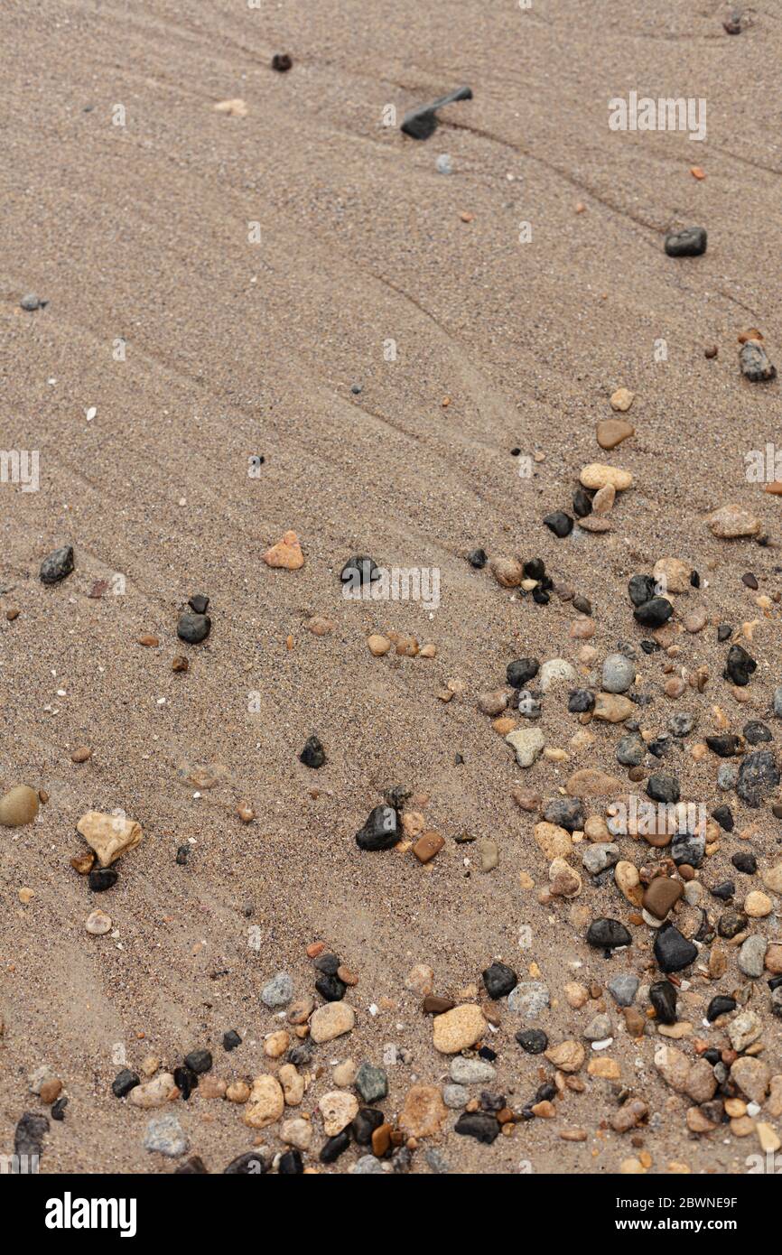 Verschiedene Struktur am Strand - Wasser und Sand, Steine und Kiesel, Wellen und Spritzer. Selektiver Fokus. Stockfoto