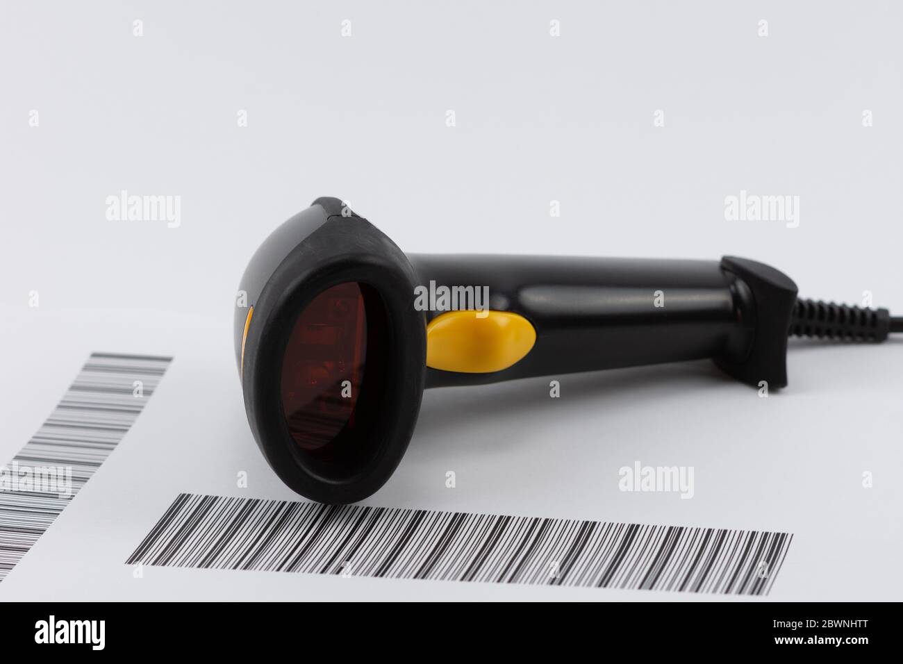 Schwarzer USB-Barcodescanner mit gelbem Verschluss auf der Barcodeliste Stockfoto
