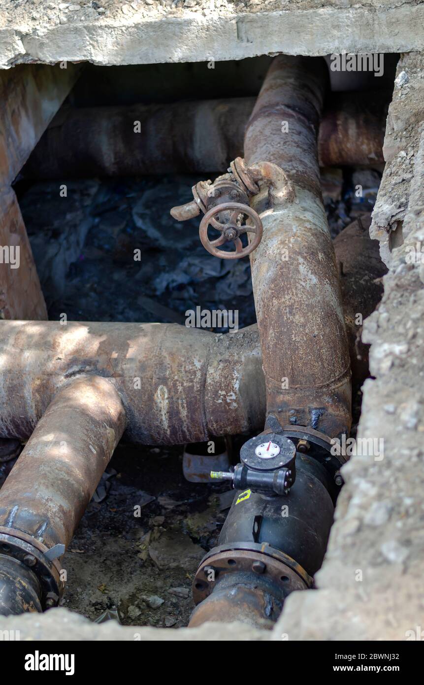 Eine offene Erdleitung mit Armaturen in einem Ziegelbrunnen. Unterirdische  Kommunikation der Wasserversorgung und Heizung. Reparatur- und  Austauschprozess Stockfotografie - Alamy