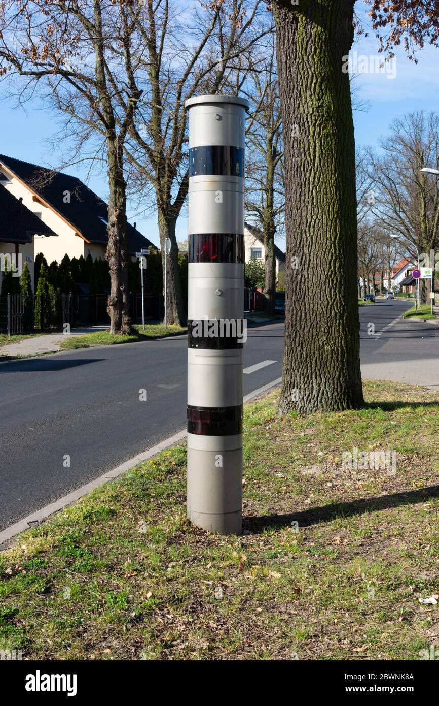 Radarkamera-Säule versteckt hinter einem Baum auf einer Straße in Berlin im Hochformat Stockfoto