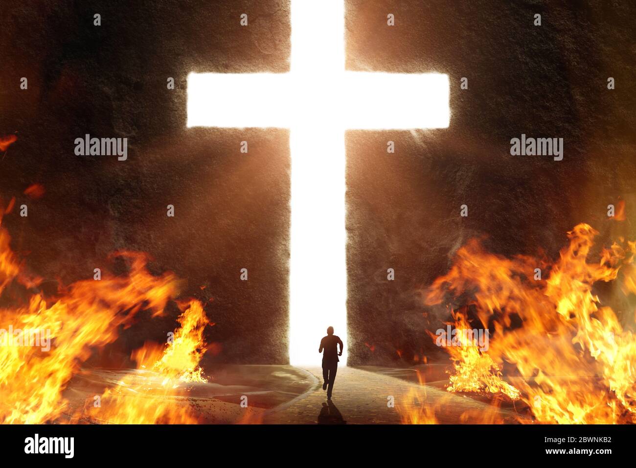 Person, die vom Feuer zur Sicherheit des Kreuzes läuft, Schnitt in einen riesigen Berg Stockfoto