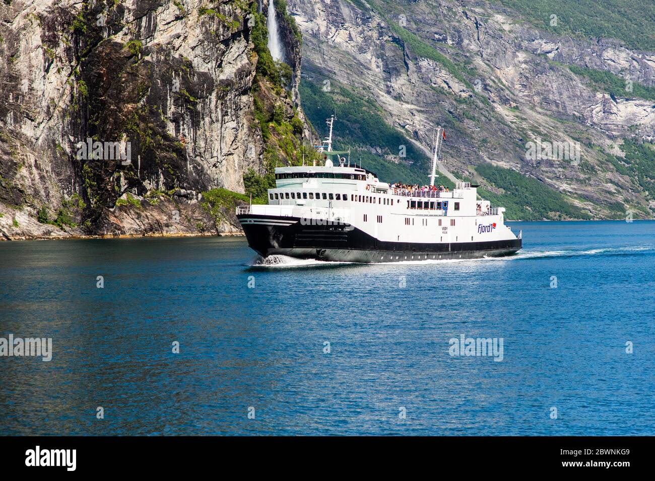 Geiranger, Geirangerfjord, Norwegen - Juni 2019: Touristisches Schiff Beerenboot schwimmende Linienschiff in der Nähe Geiranger im Geirangerfjord im Sommer Tag. Stockfoto