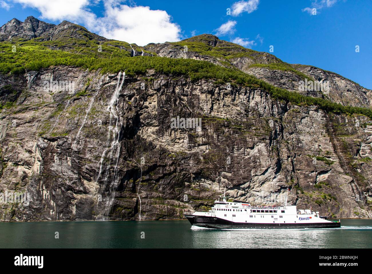 Geiranger, Geirangerfjord, Norwegen - Juni 2019: Touristisches Schiff Beerenboot schwimmende Linienschiff in der Nähe Geiranger im Geirangerfjord im Sommer Tag. Stockfoto