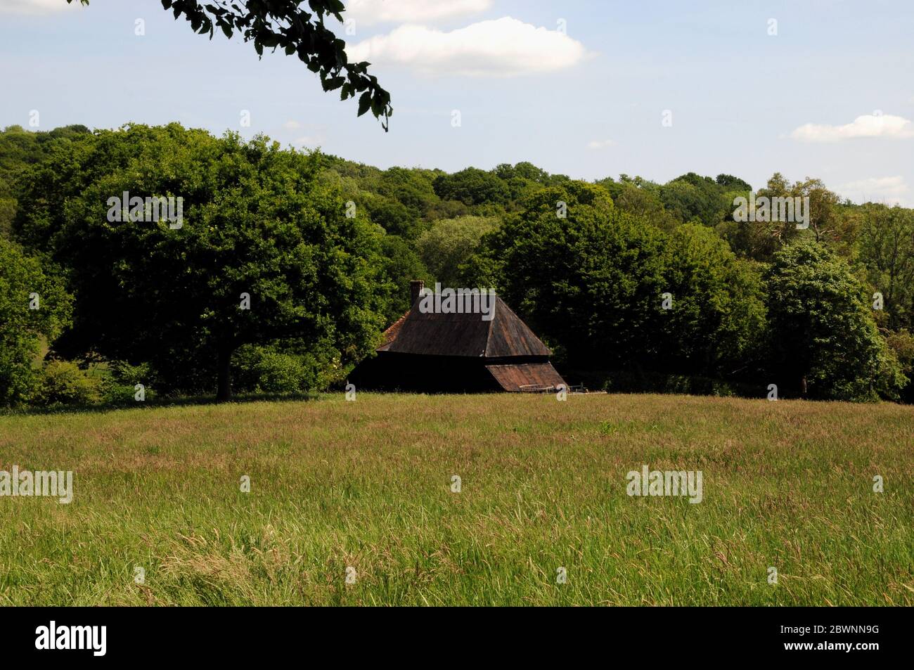 Eine Scheune schmiegt sich in die waldreiche Landschaft nahe dem Dorf Mayfield im Hochwald von East Sussex. Stockfoto