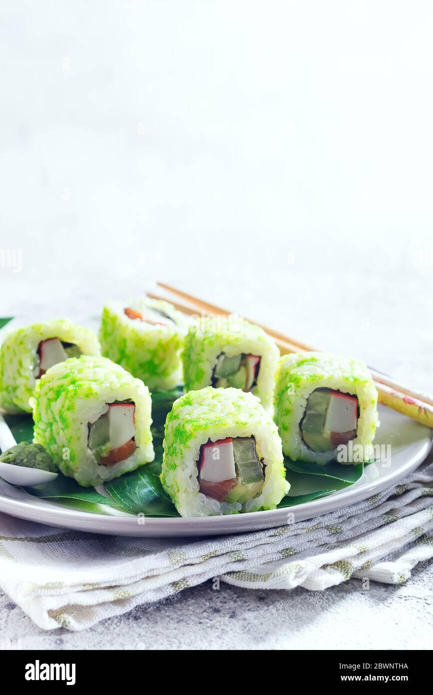 Sushi Rolle mit grünem Kaviar auf einem Teller mit Essstäbchen auf Steingrund. Sushi-Menü. Japanisches Essen Kopierbereich. Stockfoto