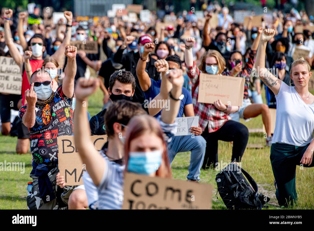 Mehrere Demonstranten in Malieveld in Den Haag, ein Knie mit ihren Plakaten, Während der Proteste gegen die "Black Lives Matter" wurden antirassistische Botschaften gezeigt.Tausende Menschen versammelten sich auf dem Malieveld in Den Haag, um gegen die Gewalt gegen schwarze Menschen in den USA und den Tod des 46-jährigen George Floyd in Polizeigewahrsam zu protestieren. Ein Video eines Zuschauers, das am 25. Mai online gepostet wurde, zeigte George Floyd, 46, und flehte bei Polizeibeamten für Atmen, während ein Offizier sich auf seinen Hals kniete, in Minnesota, USA und später seinem Tod erlag, während er in Polizeigewahrsam war. Stockfoto