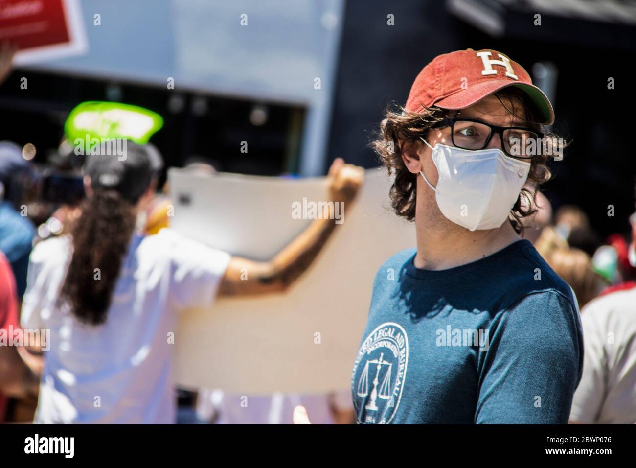 05-30-2020 Tulsa USA - Mann in Klassen und Mütze und Legal Aid Bureau T-Shirt blickt mit verschwommenen Demonstranten bei der BLM-Kundgebung hinter ihm nach hinten Stockfoto