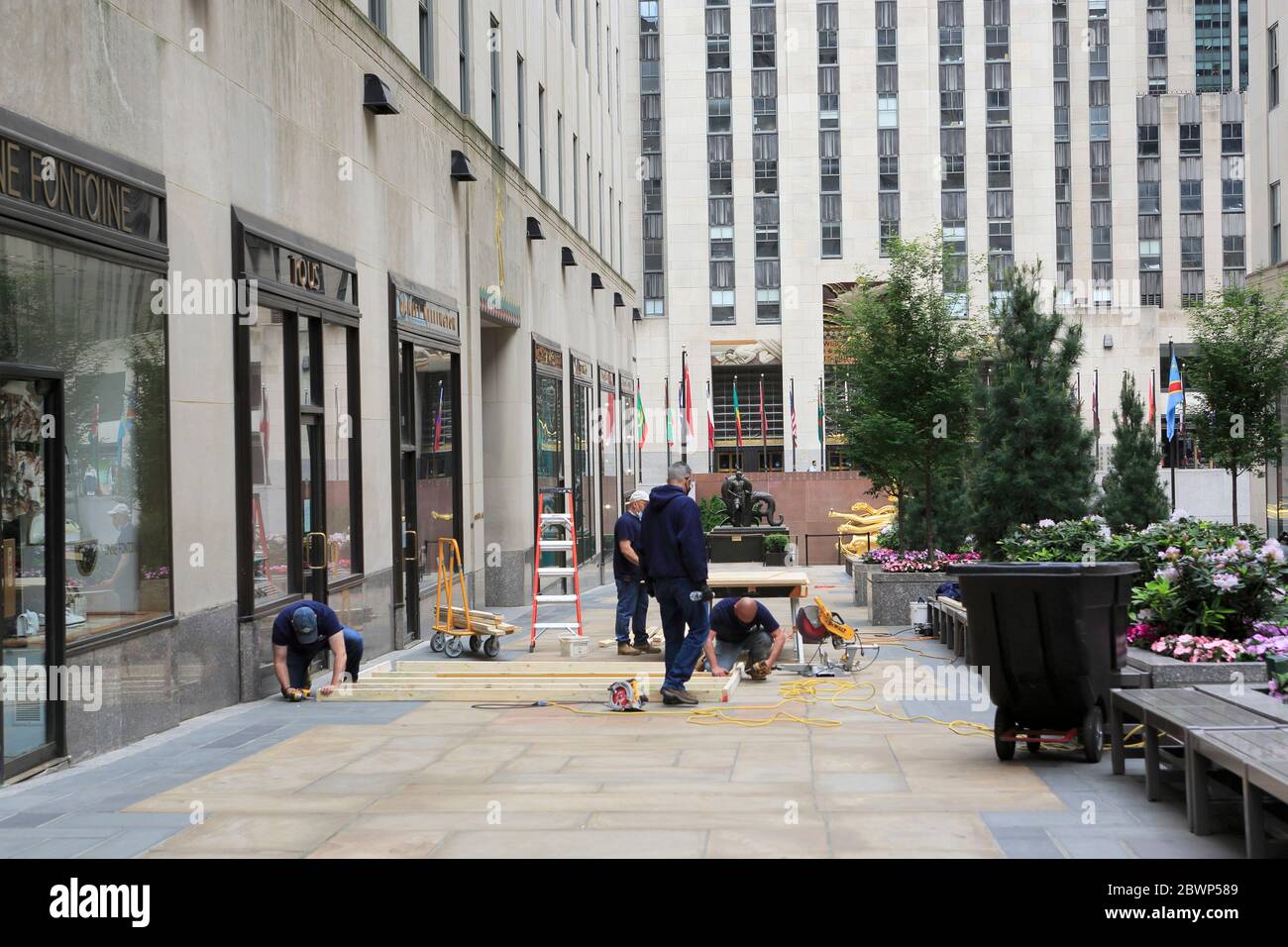 Arbeiter reparieren und besteigen Schaufenster im Rockefeller Center, nachdem Vandalen und Plünderer Proteste über den Tod von George Floyd als Gelegenheit nutzen, Chaos zu verursachen. Midtown Manhattan, New York City, USA 2. Juni 2020 Stockfoto