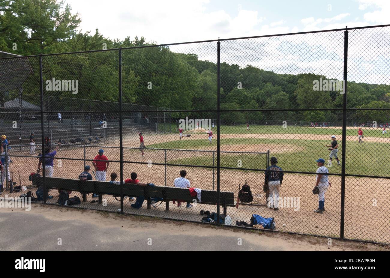 Leute, die ein Baseballspiel im Inwood Hill Park an einem Sonntag spielen, obwohl Gruppenspiele wegen der coronavirusor Covid-19 Pandemie verboten sind Stockfoto