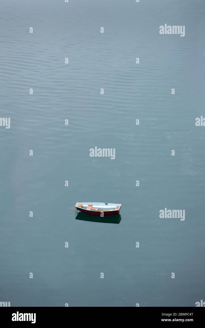 Treibend Verlassene Dinghy. Ein altes, verlassene Schlauchboot, das im Wasser liegt. Stockfoto