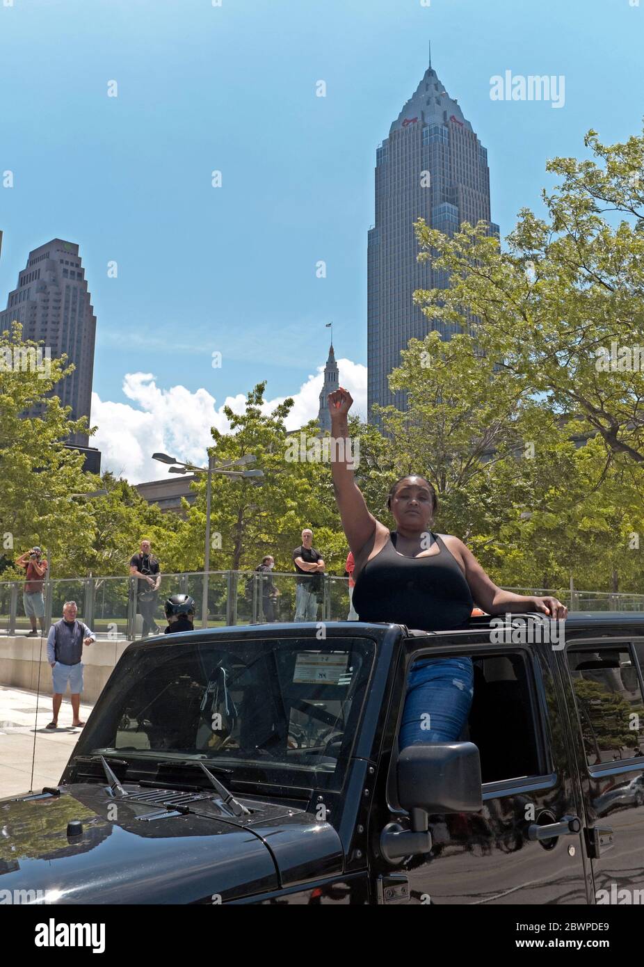 Eine schwarze Frau mit erhobener Faust steht im Auto und zeigt ihre Unterstützung für die nahe gelegene Bewegung „Black Lives Matter“, die sich am 30. Mai 2020 in Cleveland, Ohio, versammelt. Stockfoto