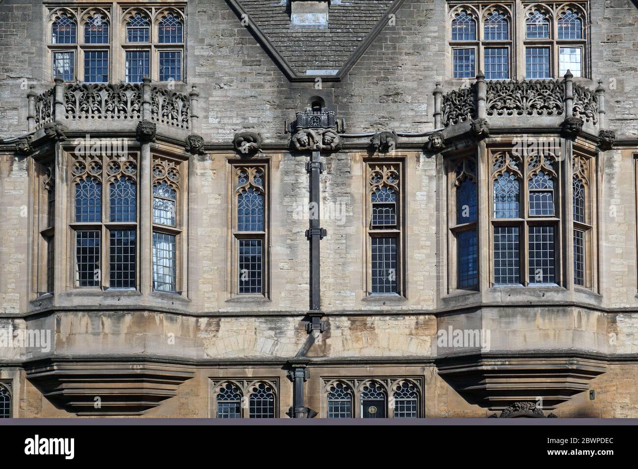 OXFORD, ENGLAND - 28. SEPTEMBER 2016: Wasserspeier und Bleiglasfenster blicken von einer der alten Oxford Colleges auf die Straße. Stockfoto