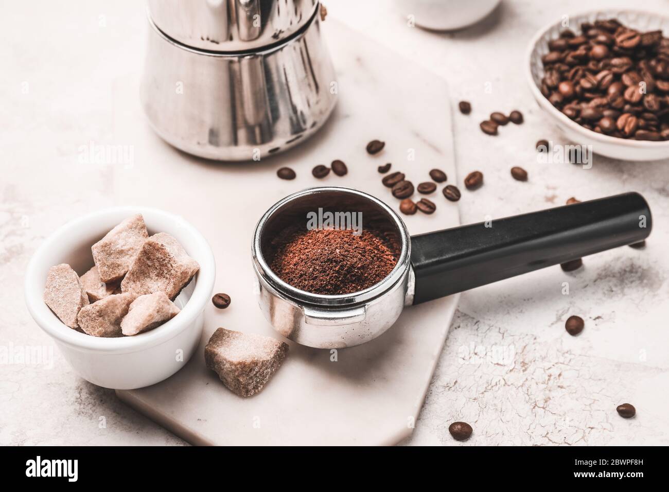Zusammensetzung mit Kaffeebohnen, Pulver und Zucker auf hellem Hintergrund Stockfoto
