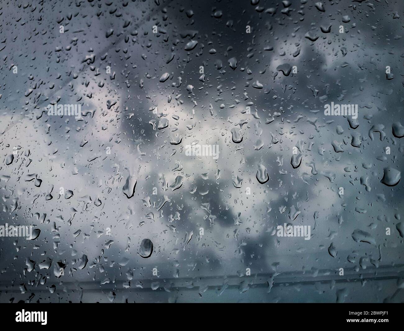 Regen fällt auf Glasfenster Stockfoto
