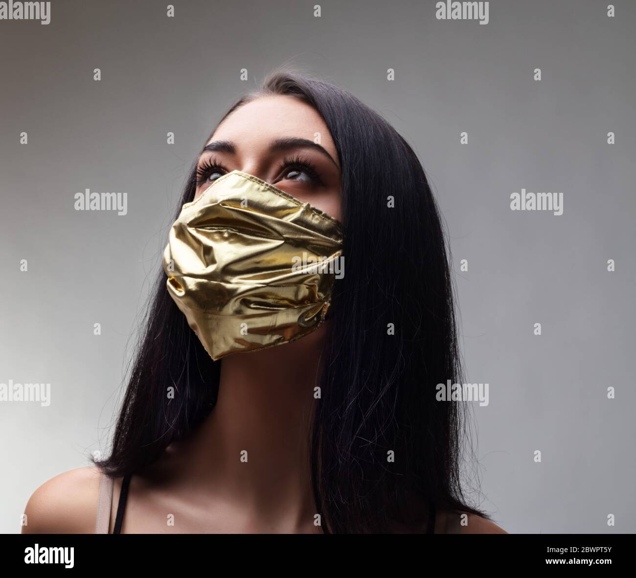 Frau trägt eine goldene Gesichtsmaske - Konzept der chirurgischen Masken Preis steigen, wenn sie obligatorisch sind und so extrem selten, wie sie benötigt werden, um t zu mildern Stockfoto