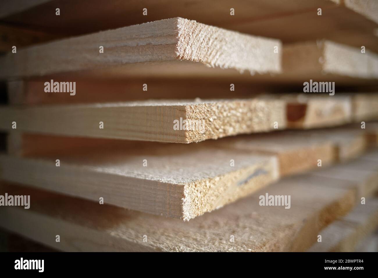 Stapel von natürlichen rauhen Holzbrettern Nahaufnahme. Lagerung von Holz in einer Tischlerei oder in einem Sägewerk Stockfoto