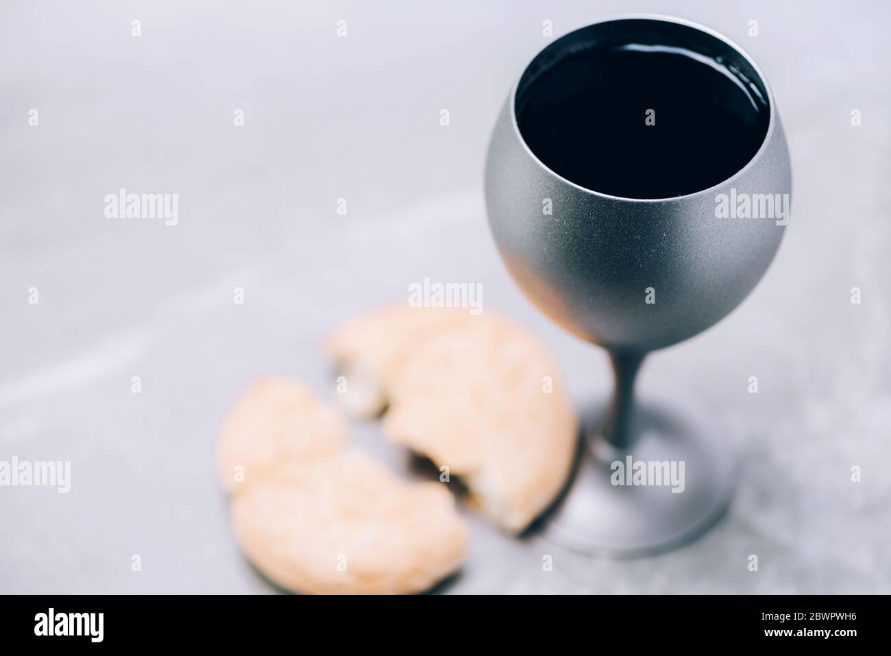 Gemeinschaft Stillleben. Ungesäuertes Brot, Kelch Wein auf grauem Hintergrund. Konzept der christlichen Kommunion zur Erinnerung an das Opfer Jesu. Ostern Stockfoto