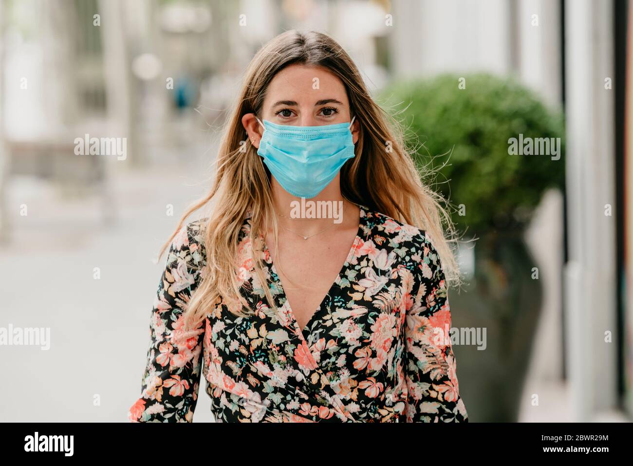 Mädchen, das während des Coronavirus eine Straße in spanien mit medizinischer Maske entlang geht Stockfoto