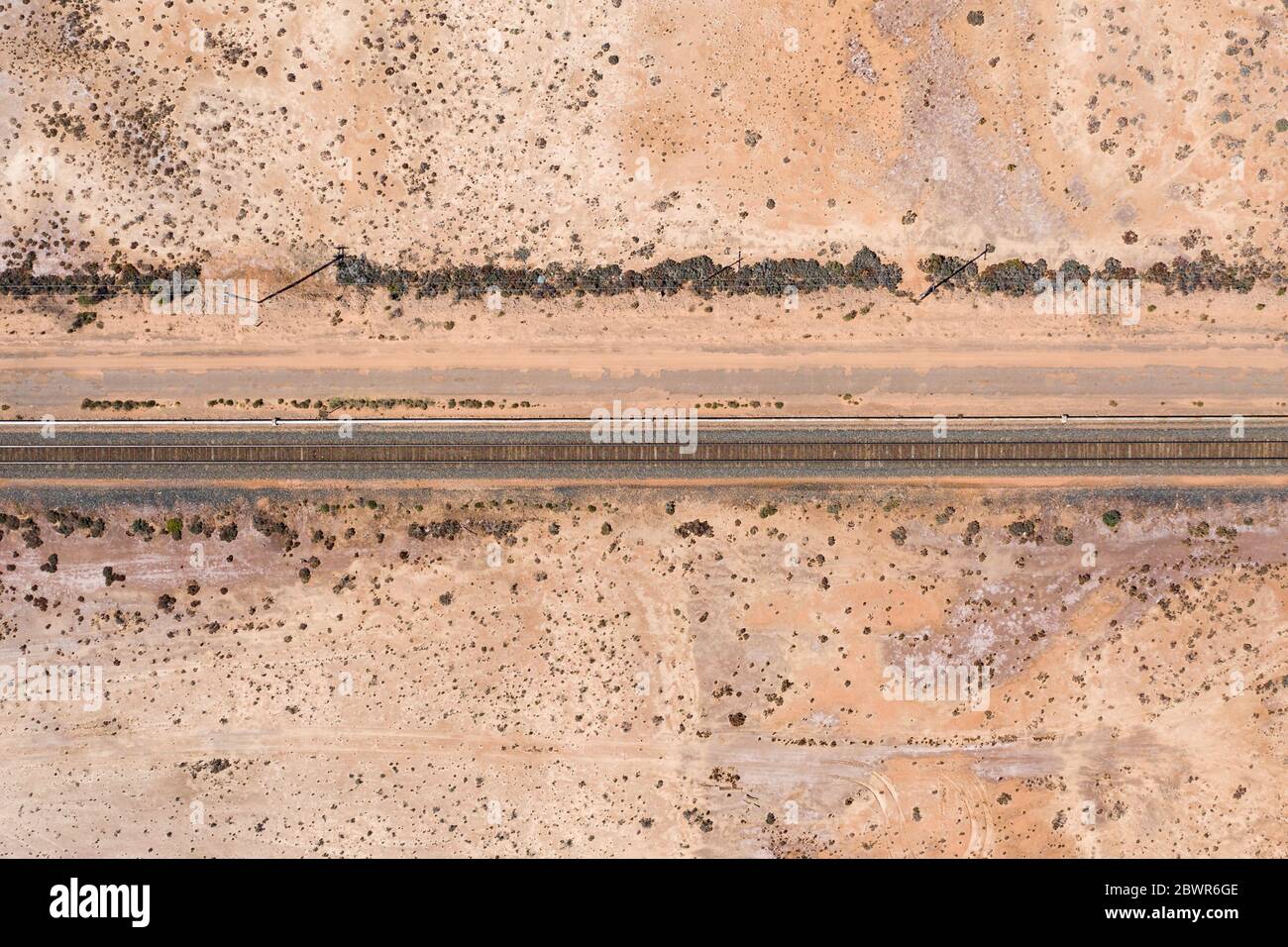 Luftaufnahme der Eisenbahnlinie auf dem trockenen rosa See auf dem Coolgardie-Esperance-Highyway nördlich von Norseman in Westaustralien Stockfoto