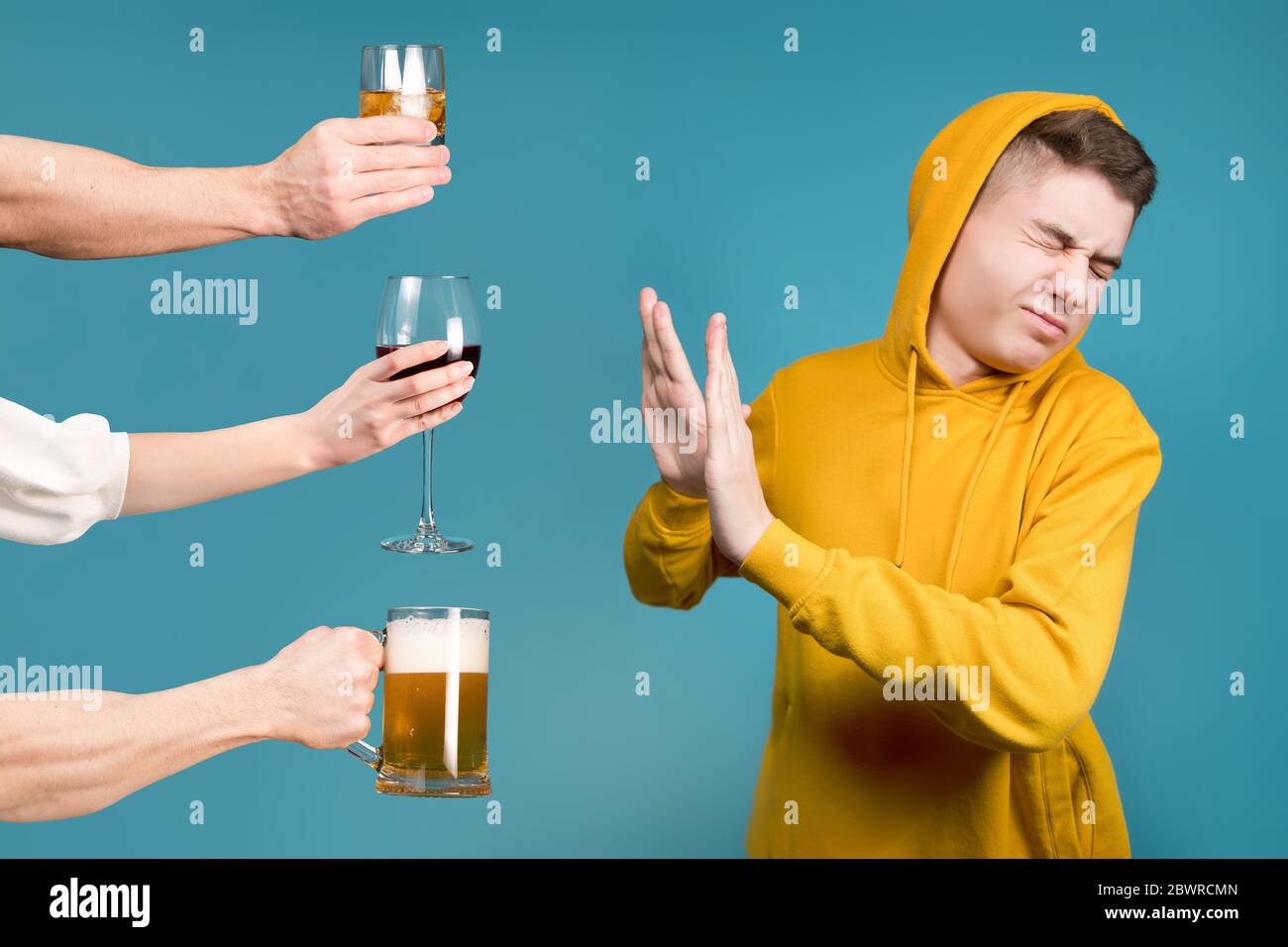 Teenager in einem gelben Sweatshirt verweigert verschiedene Arten von Alkohol Stockfoto