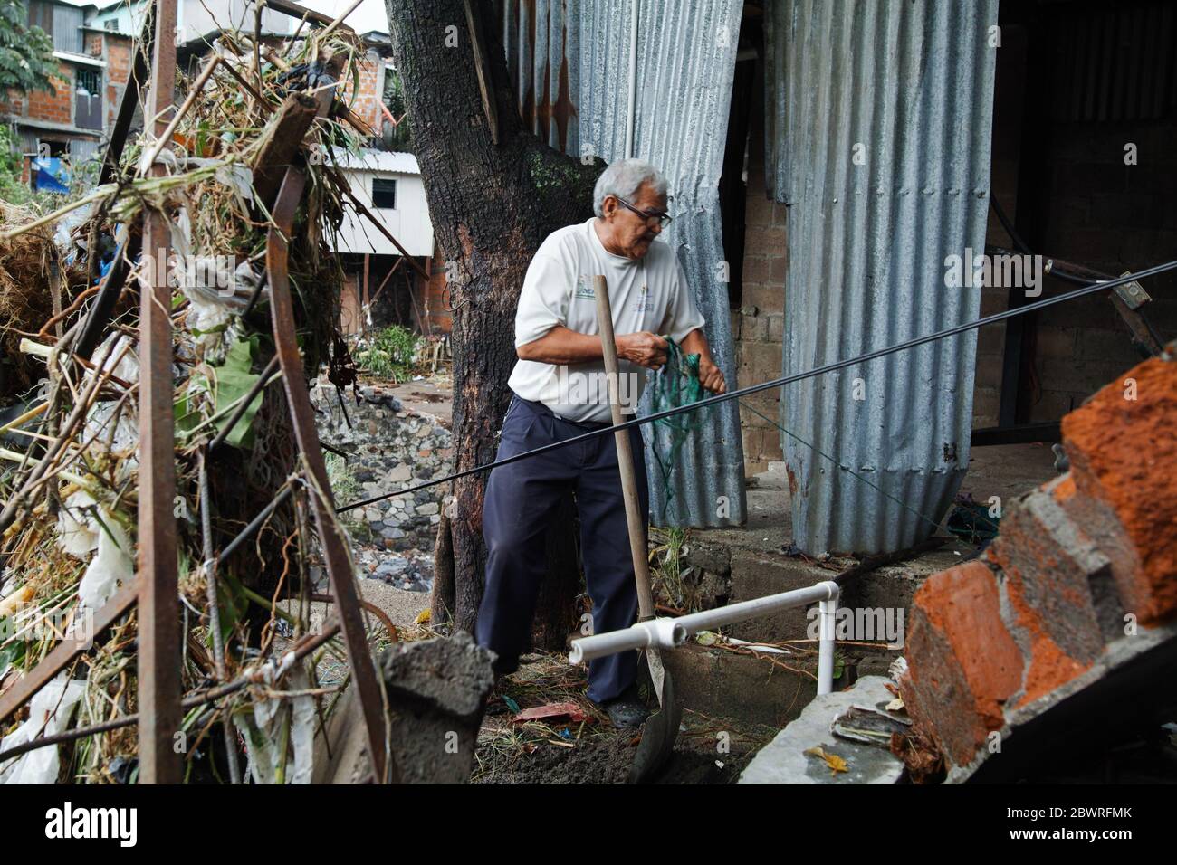 San Salvador, El Salvador. Juni 2020. Ein älterer Bürger, der Trümmer entfernt, die durch den Tropensturm Amanda in der Nuevo Israel Community in der Hauptstadt El Salvador verursacht wurden. Die Gemeinde liegt am Ufer des Arenal Flusses, der aufgrund der intensiven Regenfälle am Sonntag und Montag viele Häuser überschwemmt und zerstört hat. Kredit: Carlos Diaz/Alamy Live News. Stockfoto