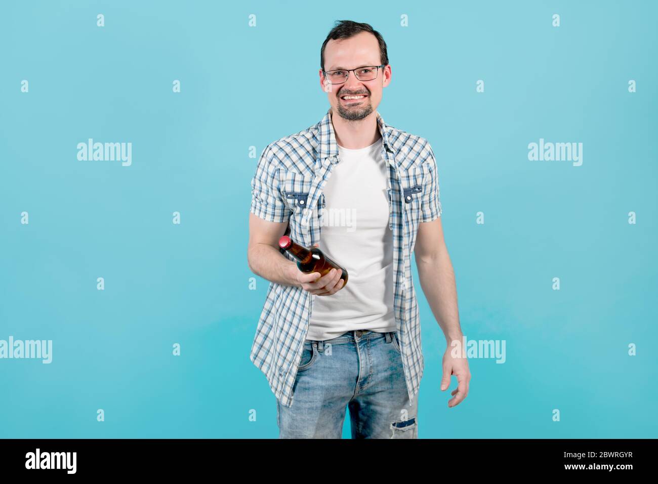 Mann in einem karierten Hemd mit Borsten in Gläsern hält Eine Flasche Bier in der Hand Stockfoto