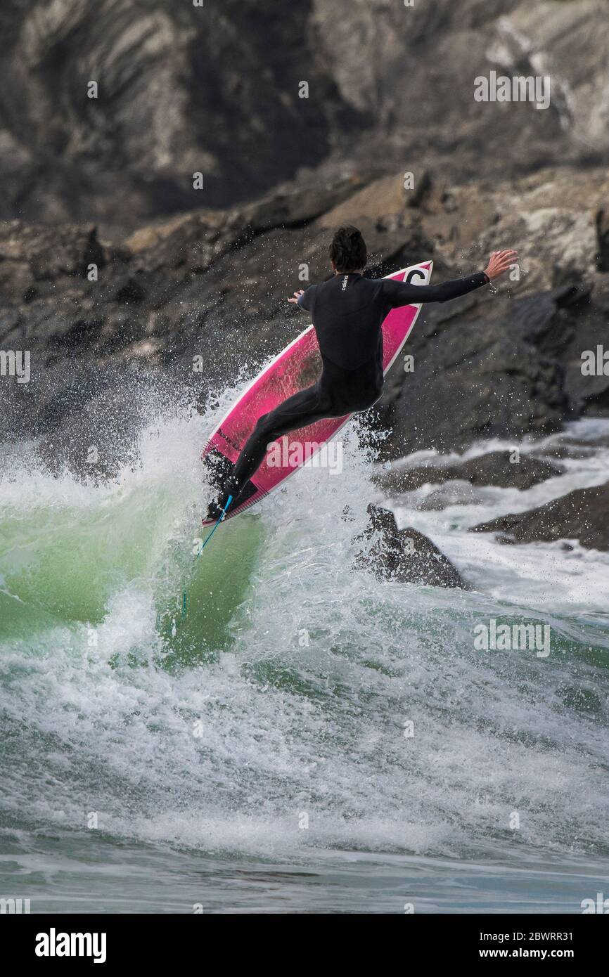 Spektakuläre Action, wenn ein Surfer von einer Welle bei Fistral in Newquay in Cornwall in die Luft kommt. Stockfoto